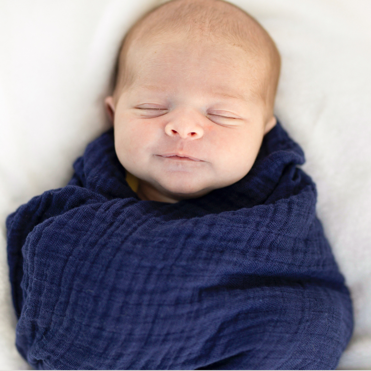 newborn wrapped in blue blanket